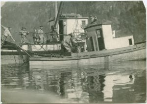 Fishermen pulling catch into a fishing boat