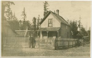 A person is standing in front of fenced house.
