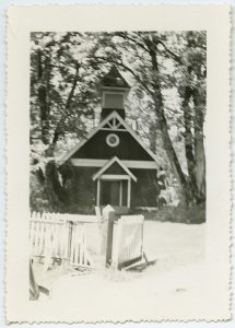 Exterior view of church building with fence in forefront.